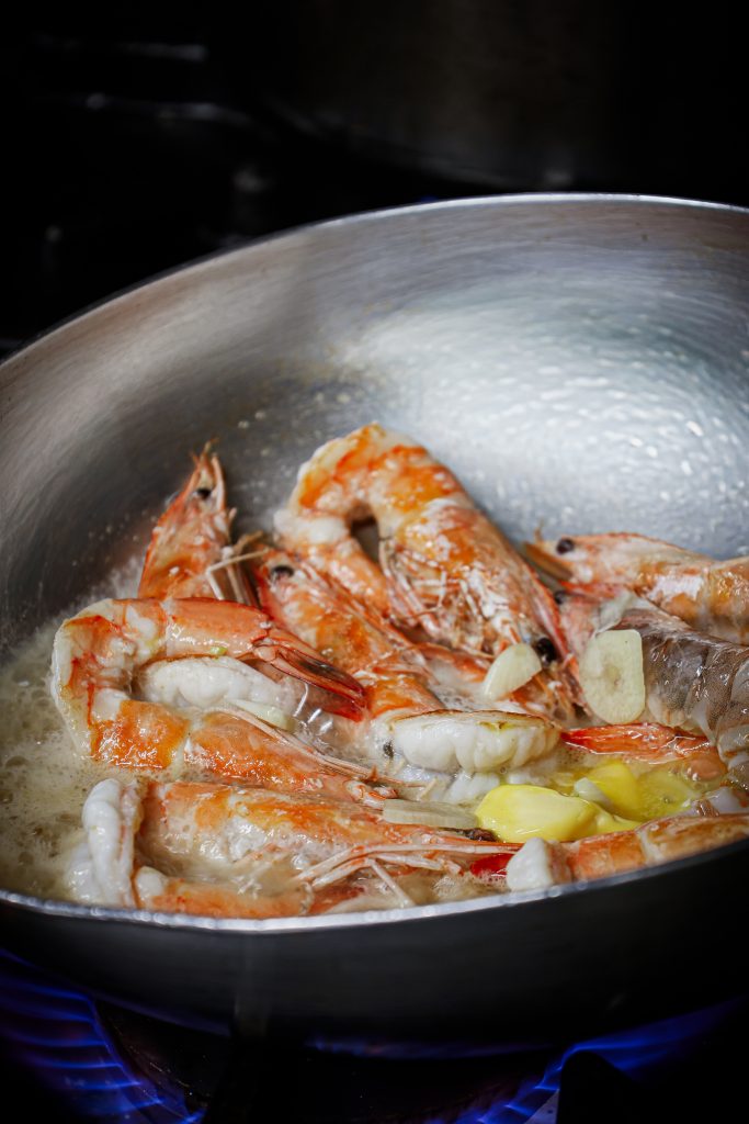 Prawns tossed in a steel pan over the heat