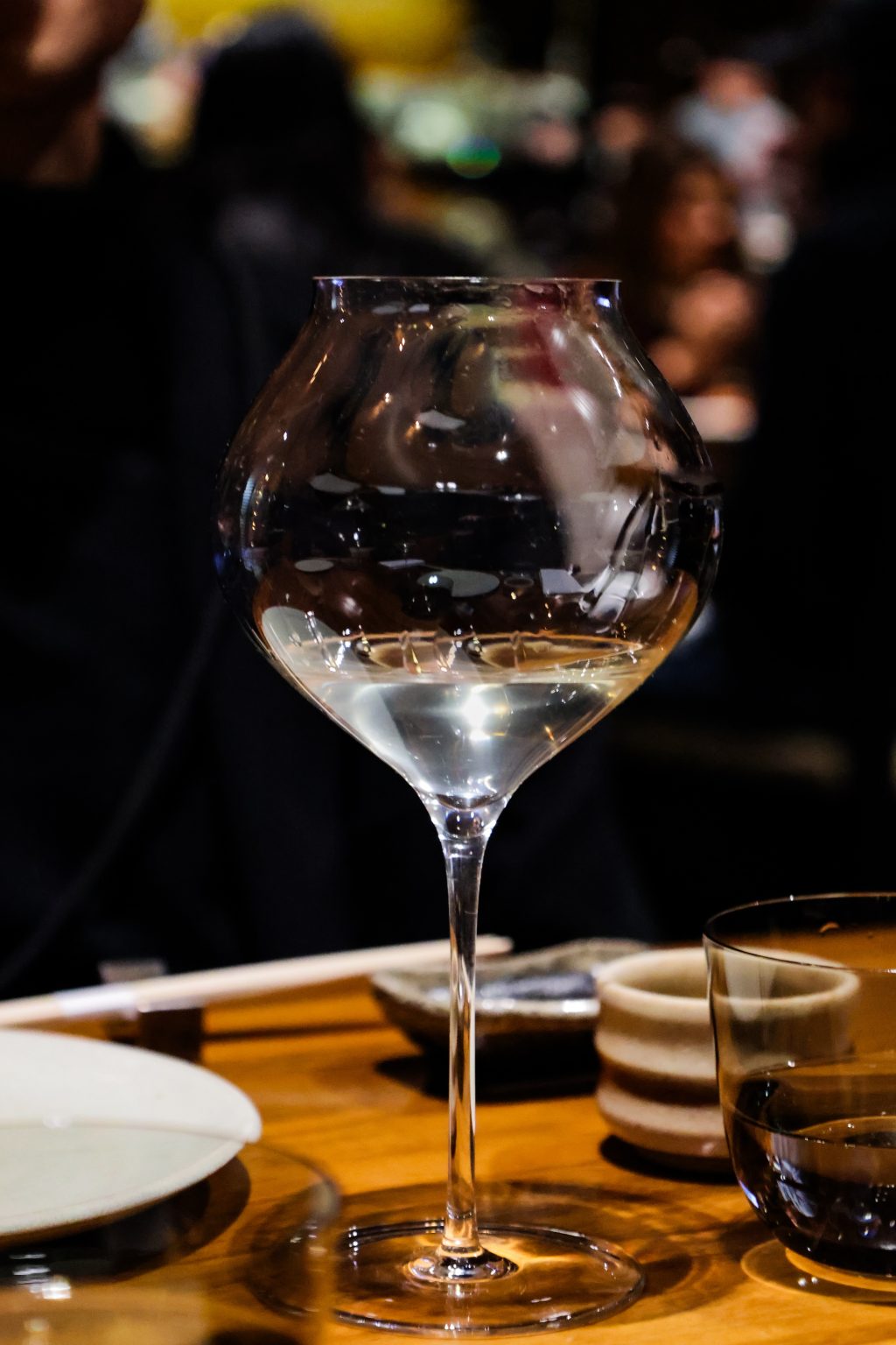 Glass of white wine on a restaurant table at night