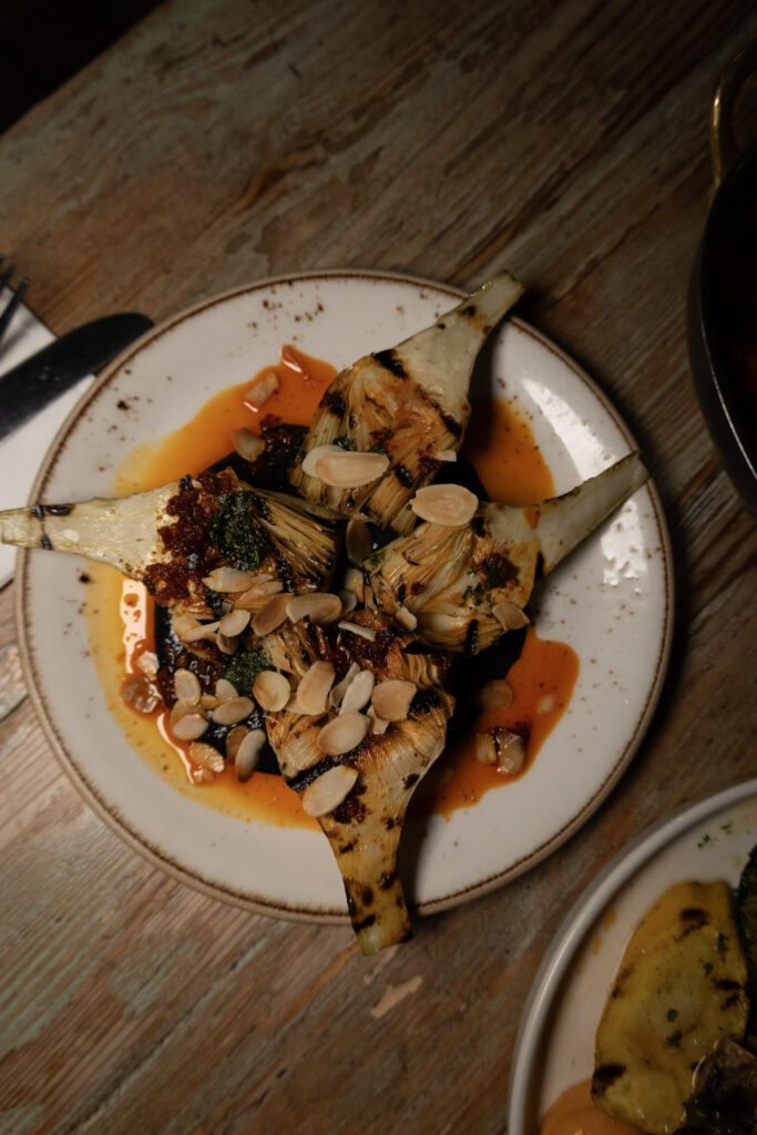 Grilled aubergine with toasted almonds and a bright sauce, shot from above